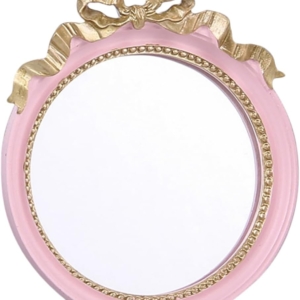 A pink and gold mirror with a bow on it, perfect for tween girl bedroom.