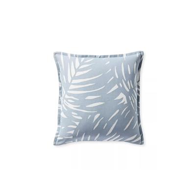 A tropical-themed pillow with blue and white colors and palm leaves design.