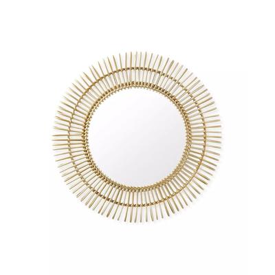 A circular gold mirror with a white background design.