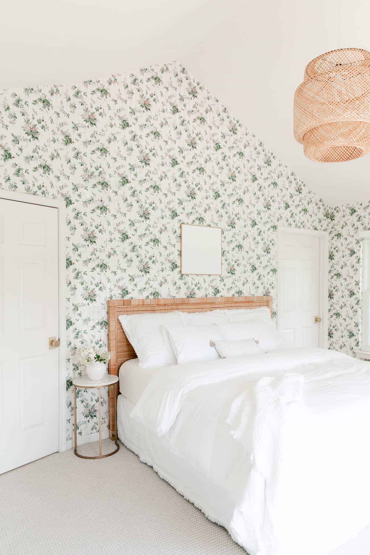 ikea pendant light over rattan bed with white bedding in wallpaper bedroom