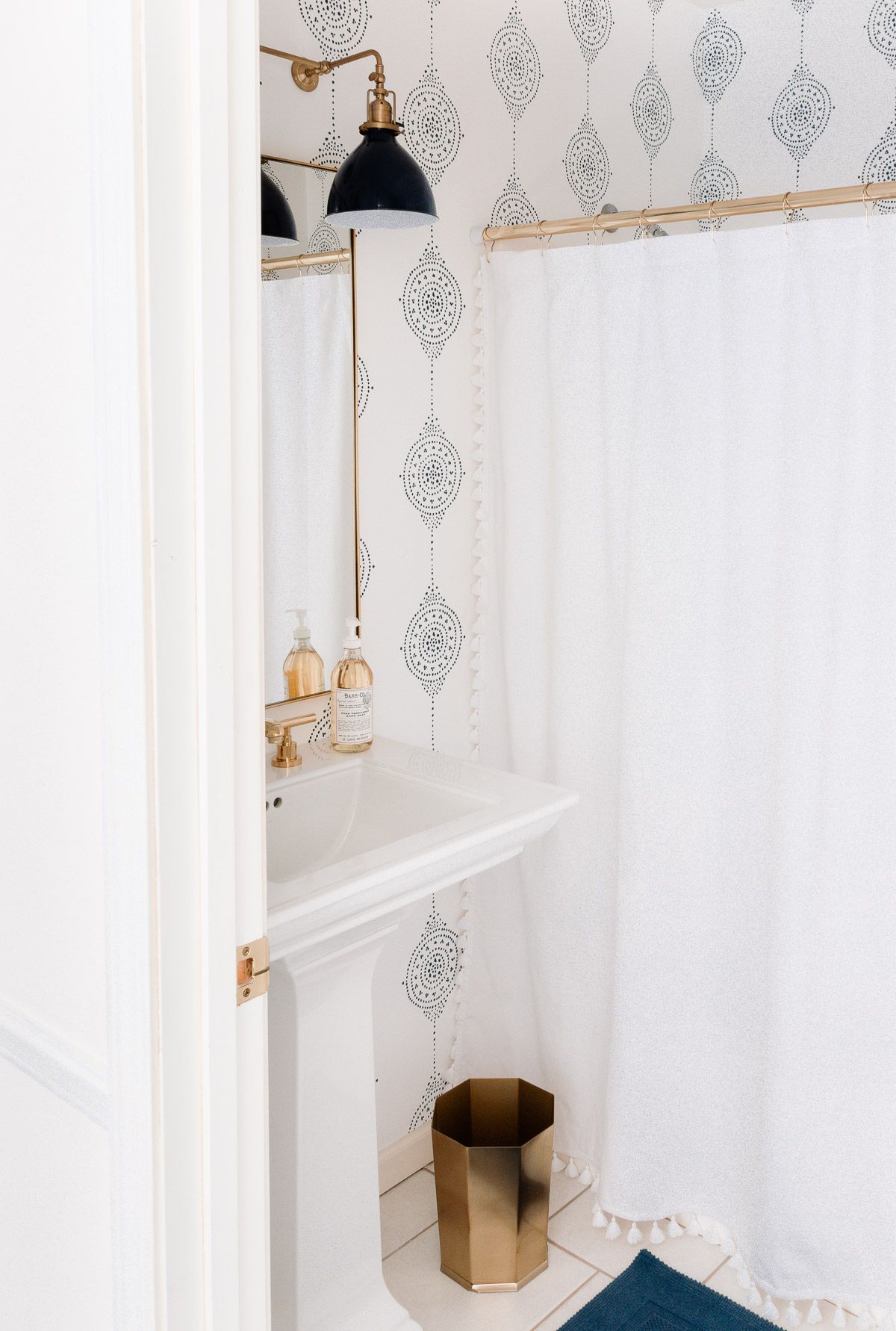 A coastal modern bathroom with navy and white striped wallpaper from Serena and Lily