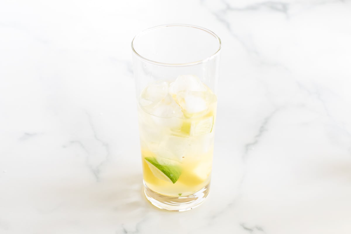 pineapple and ice in a clear glass on a marble countertop
