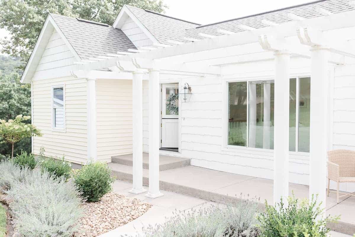 ranch house with a pergola attached to a house, lavender and boxwood plantings