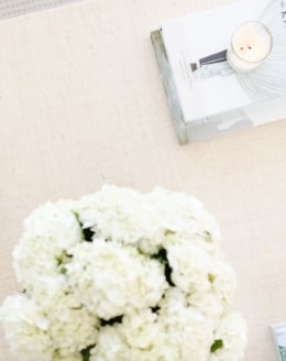 White flowers and coffee table books on a modern coastal coffee table