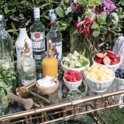 A mojito bar set up outdoors on a gold bar cart