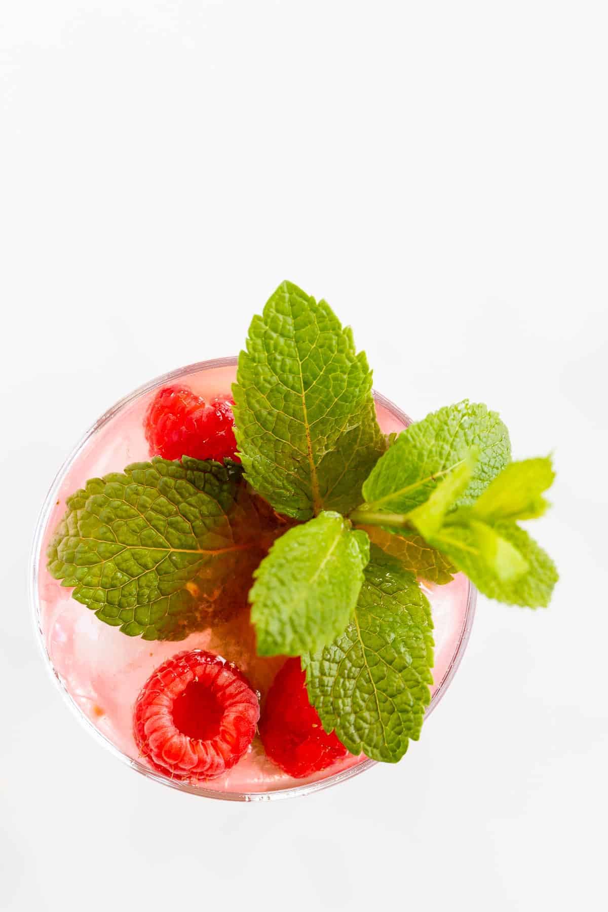 cocktail glass with raspberries and mint