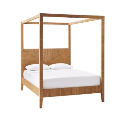 A rattan canopy bed with white sheets.