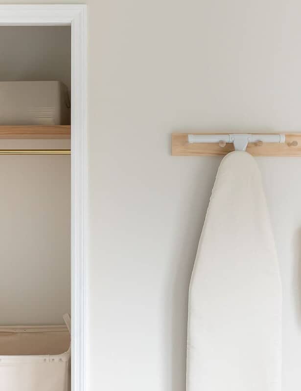 A storage area in a second floor laundry room, with a wooden shelf and peg rail.