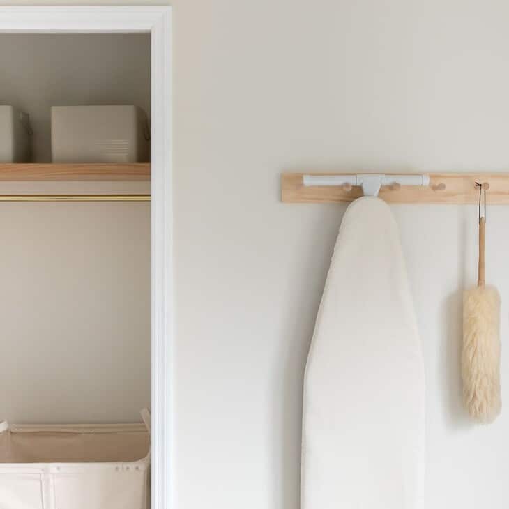 A storage area in a second floor laundry room, with a wooden shelf and peg rail.