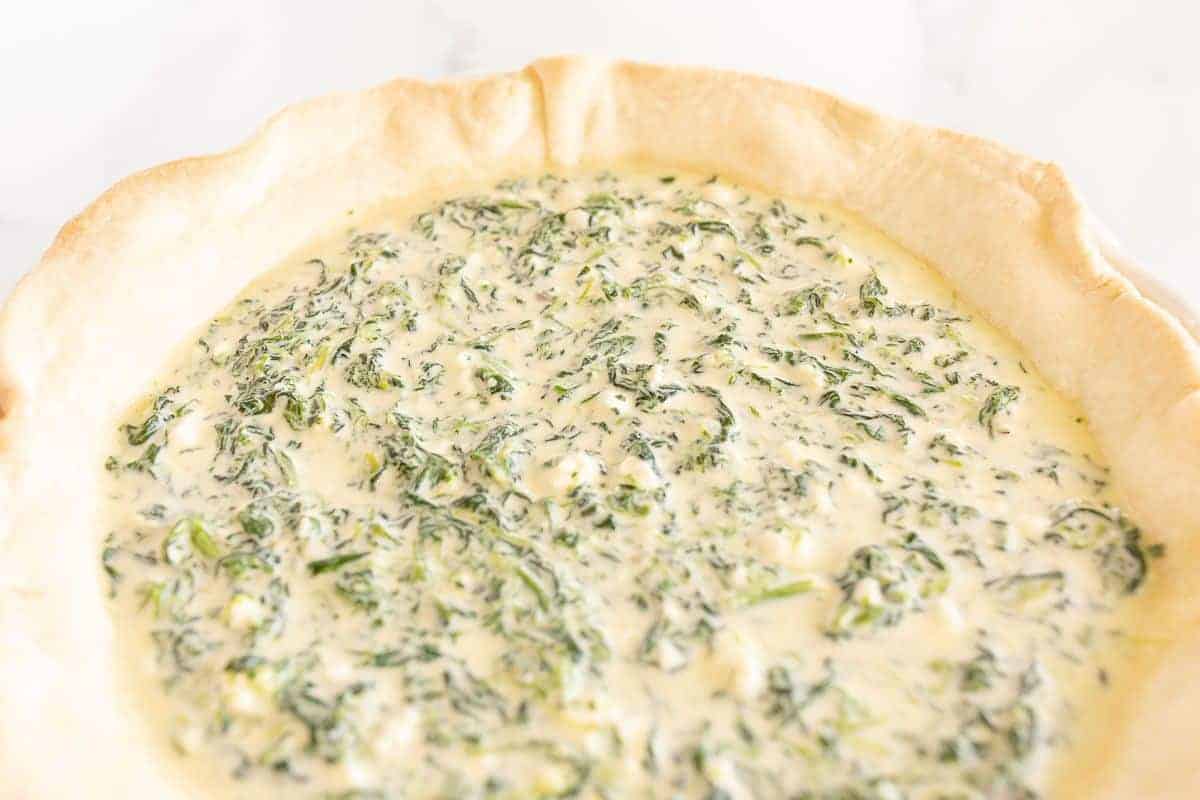 A spinach quiche before it goes in the oven to be baked.