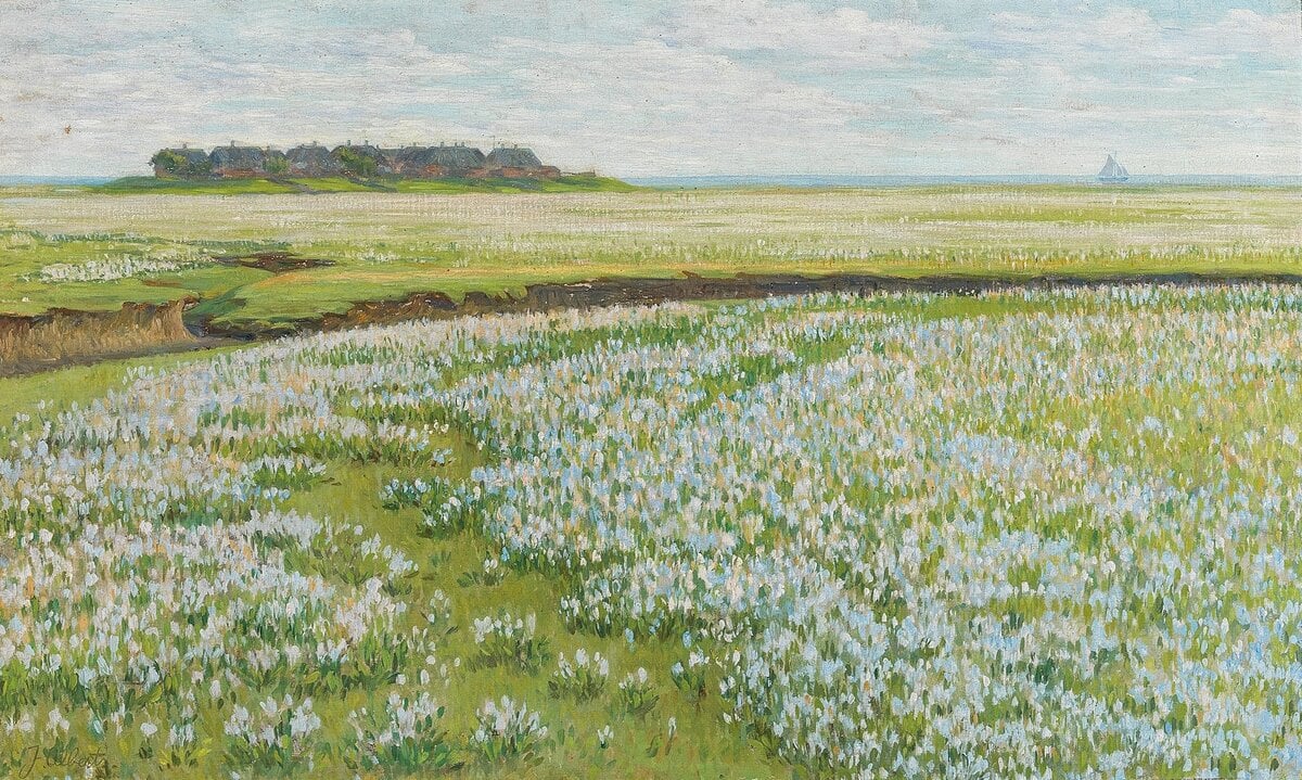 A grassy coastal landscape with patches of white wildflowers is beautifully displayed on a Samsung Frame TV, featuring a distant island with trees and a sailboat on the horizon under a partly cloudy sky.