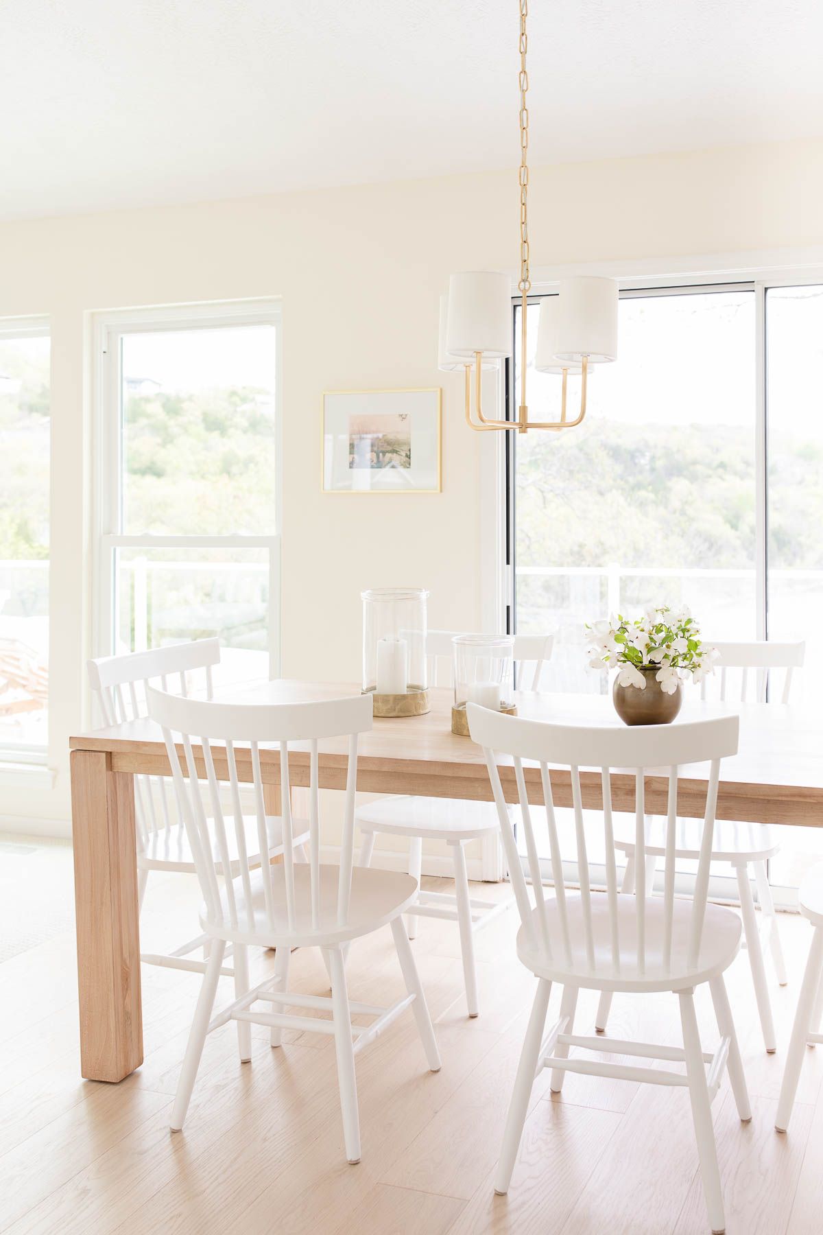 A white kitchen dining area with wide white oak floors.