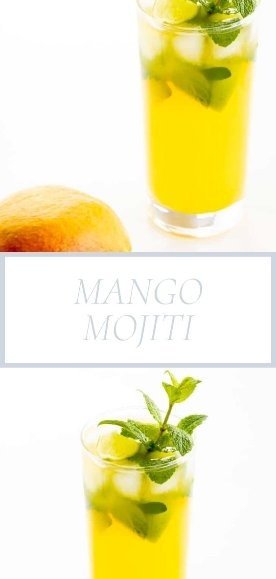 On a marble counter top there is a mango mojito next to a fresh mango.