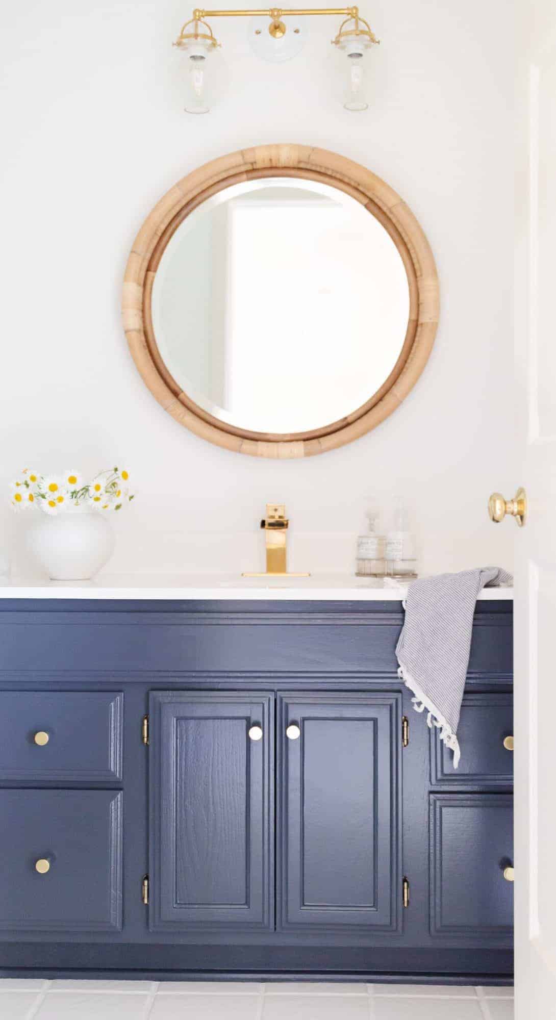 A white bathroom with a vanity painted in Benjamin Moore Hale Navy.
