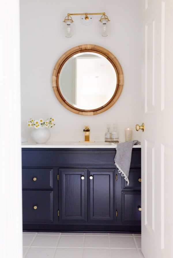 A white bathroom with a vanity painted in Benjamin Moore Hale Navy.