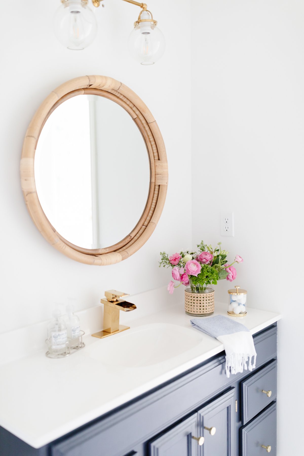 A white bathroom with a vanity painted in Benjamin Moore Hale Navy.