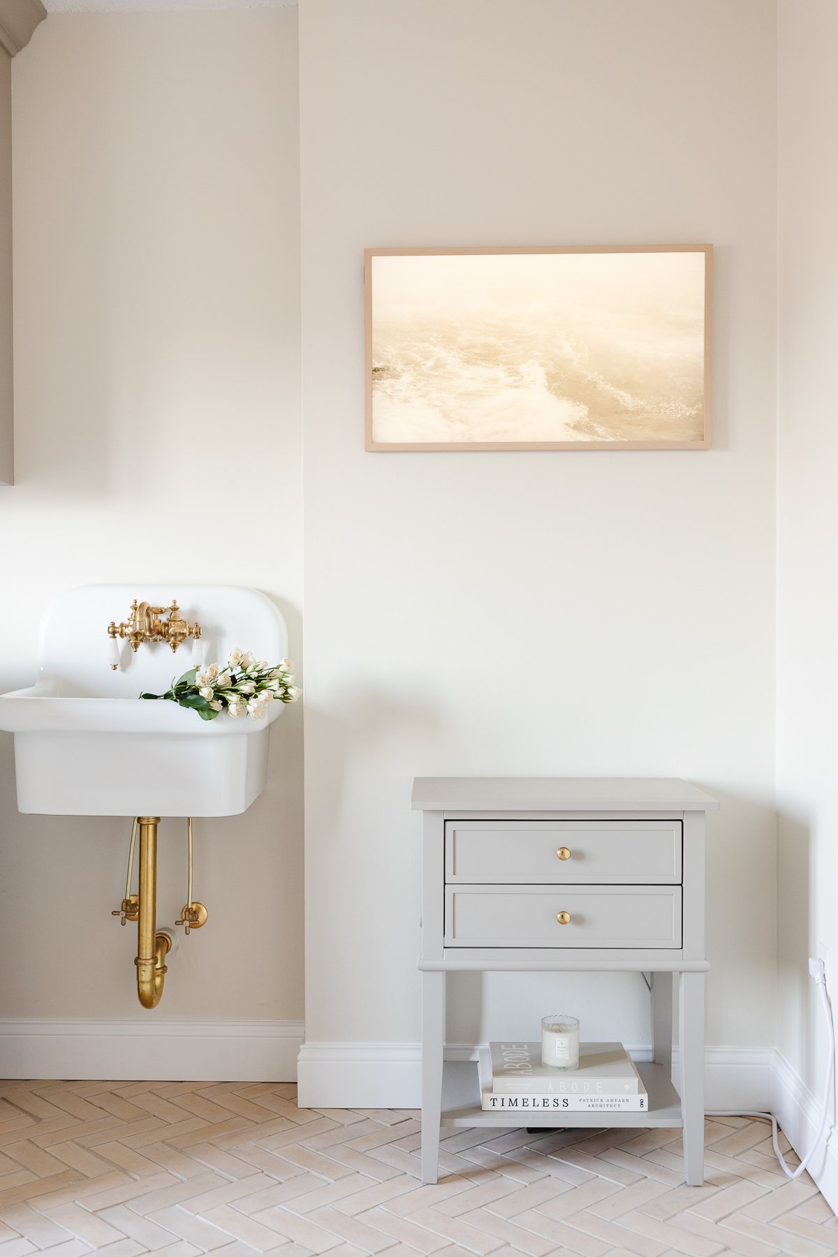 A bathroom with a sink and a mirror that is painted in Benjamin Moore Swiss Coffee.