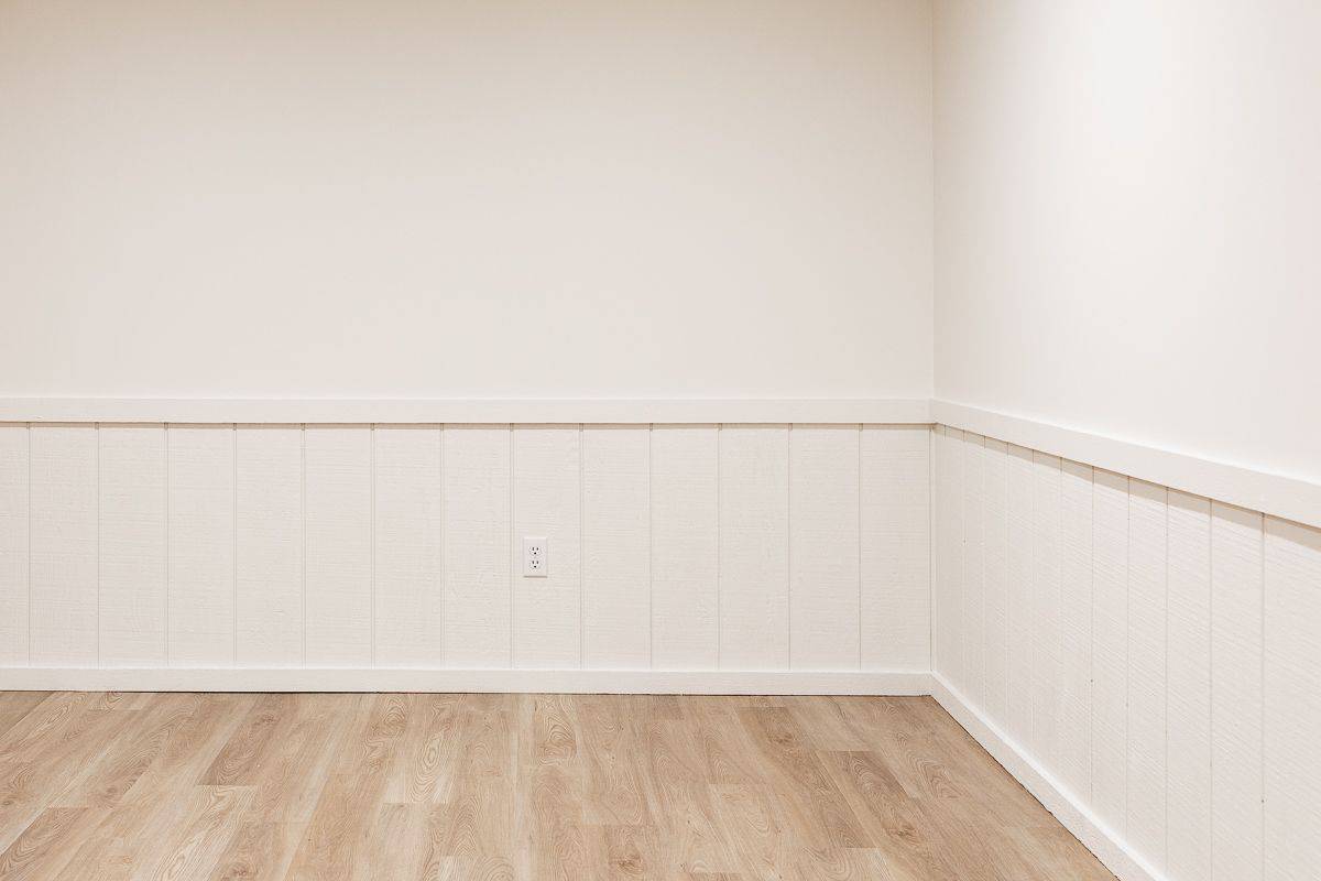 A freshly painted basement with LRV floors and Benjamin Moore Swiss Coffee paint color on the walls