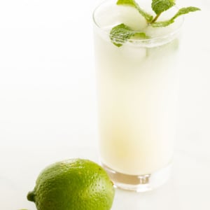 A coconut mojito garnished with mint on a marble surface.