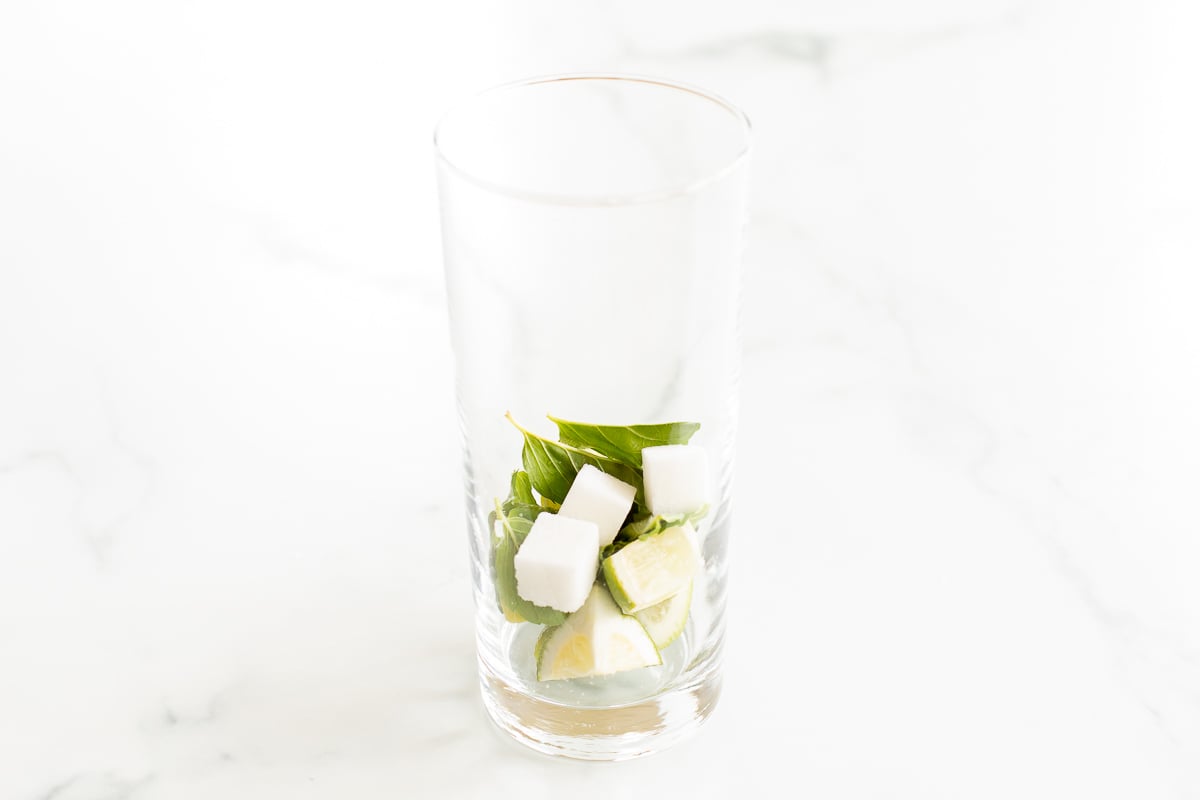 Sugar cubes and mint and sliced limes in the bottle of a cup.