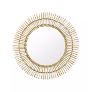 A circular mirror with gold spikes on a white background, perfect for lake house decor.