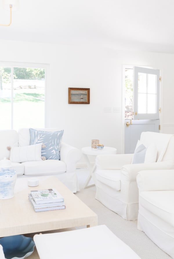 A living room with white furniture in lake house decor.