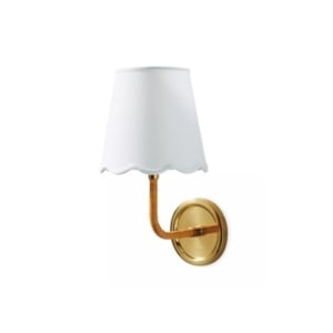 A gold sconce with a white shade, perfect for lake house decor.