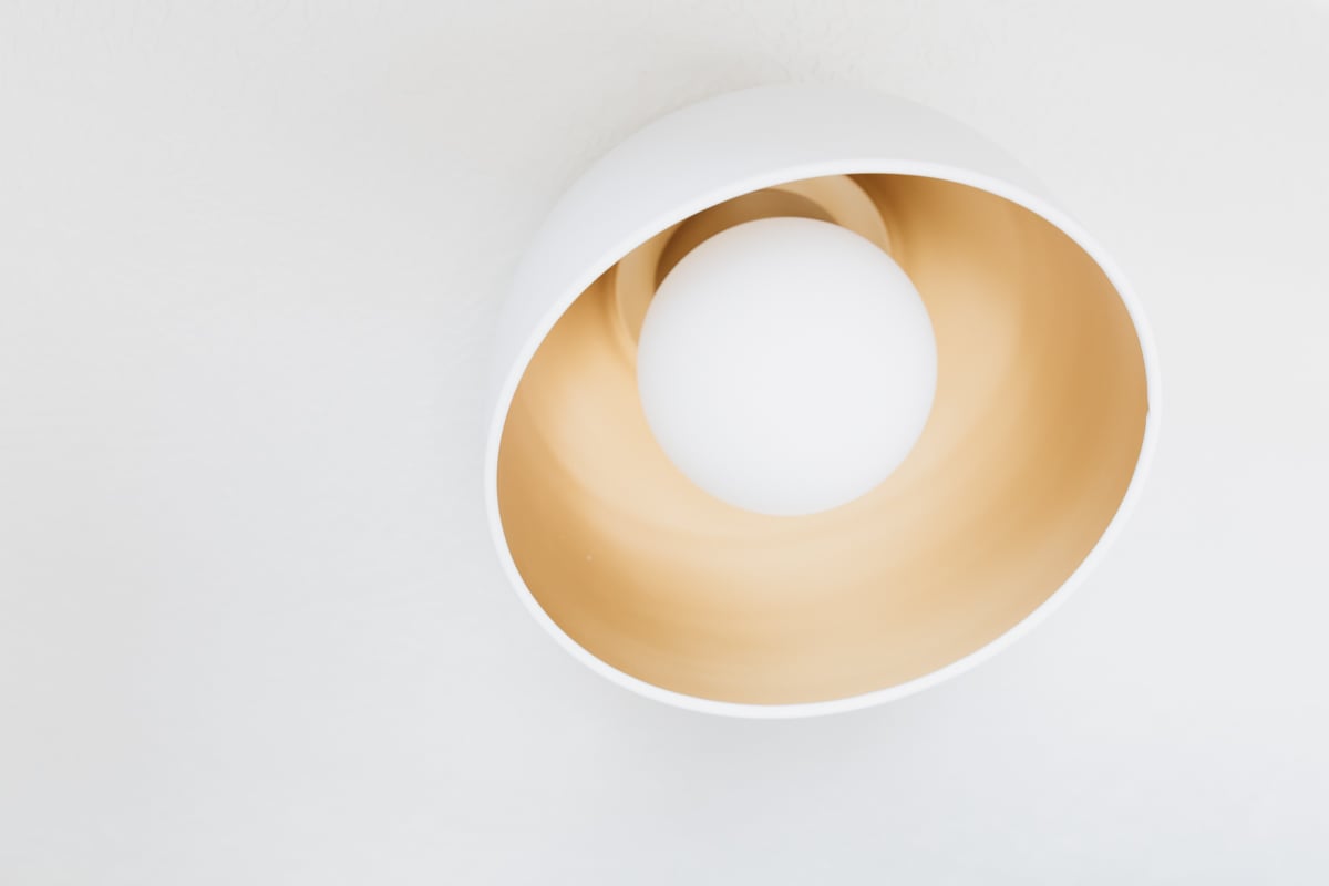 A white wall light with a circular shape, perfect for illuminating any laundry closet or laundry room.