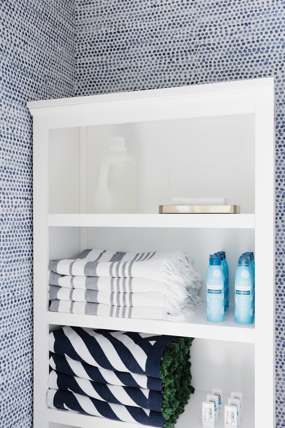 A clean and minimalist white shelf adorned with soft blue and white towels, perfect for a laundry room closet.