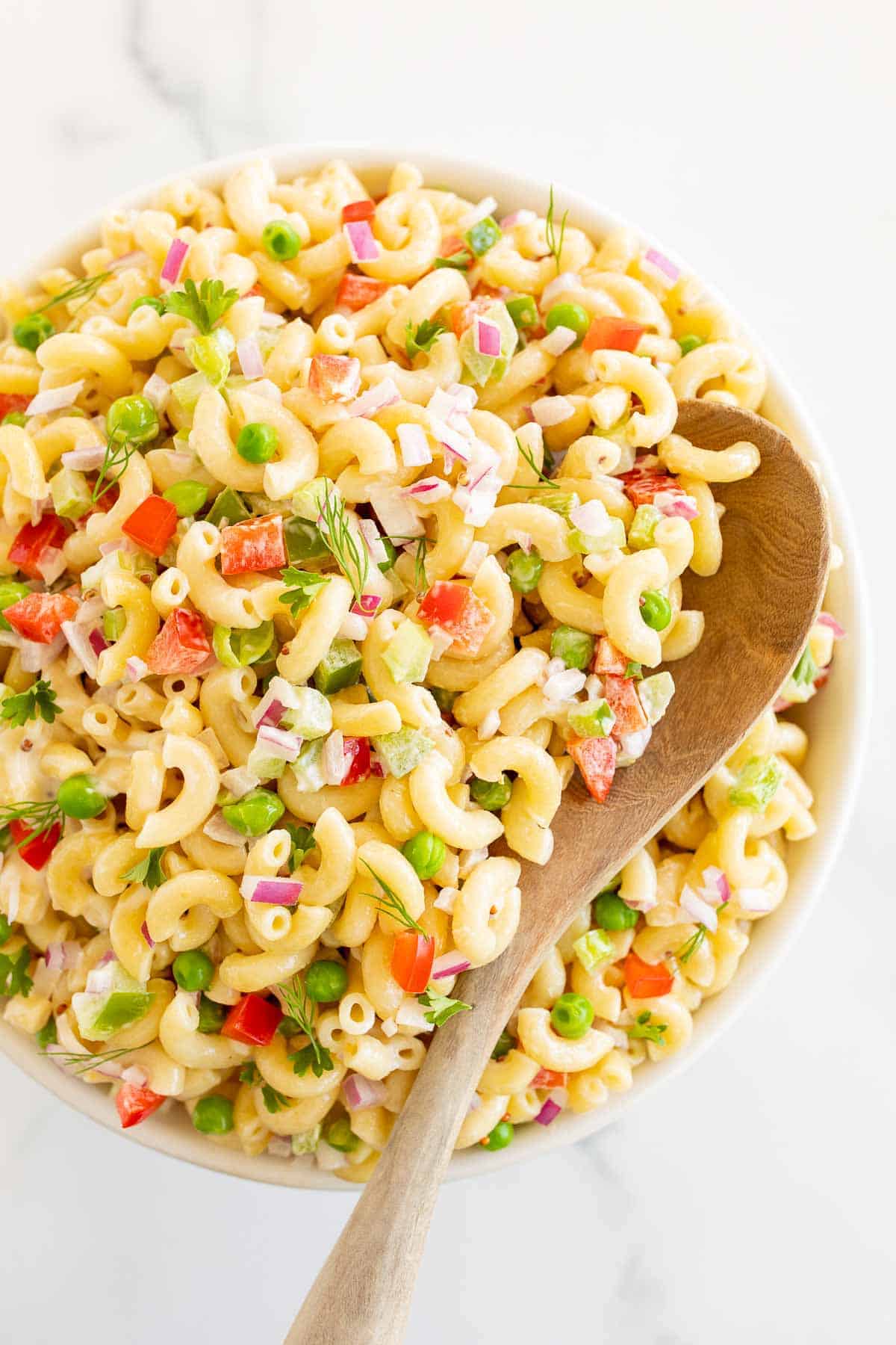 bowl of pasta salad with wood spoon