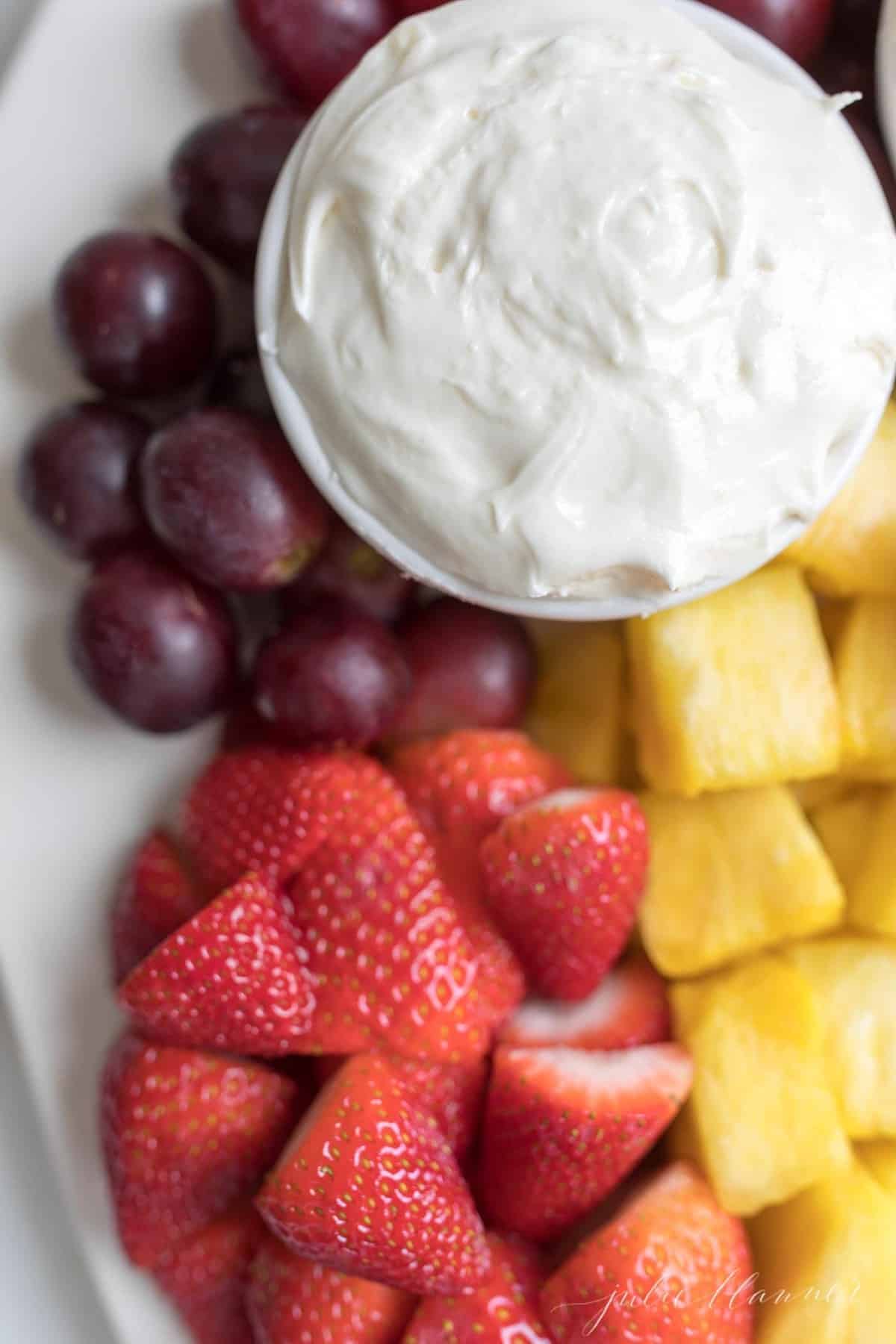 cream cheese fruit dip in a white bowl next to a fruit platter