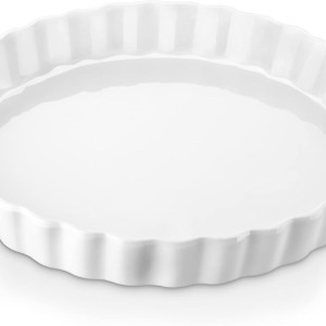 A white, round ceramic fluted tart pan, perfect for baking a delicious quiche lorraine, on a white background.