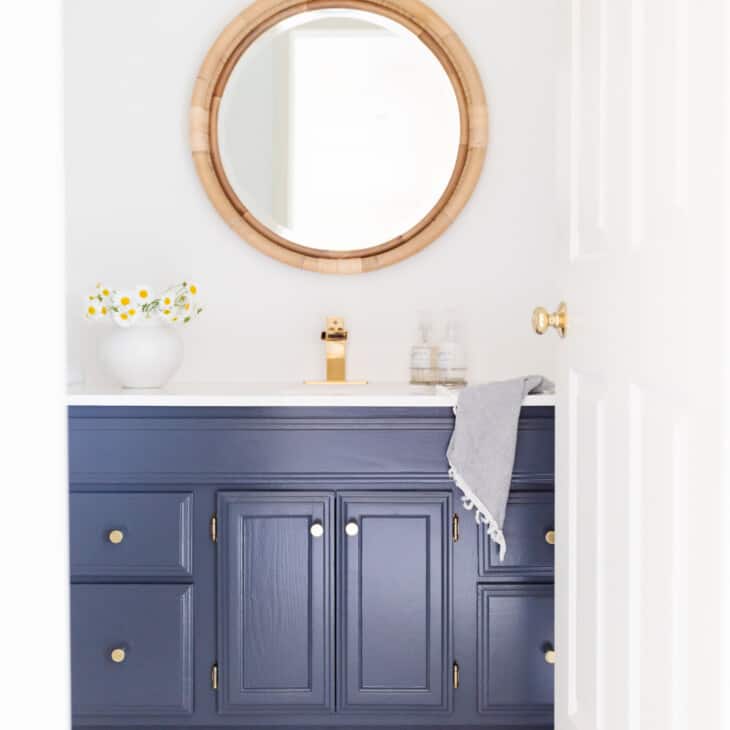 navy and white nautical bathroom with rattan mirror