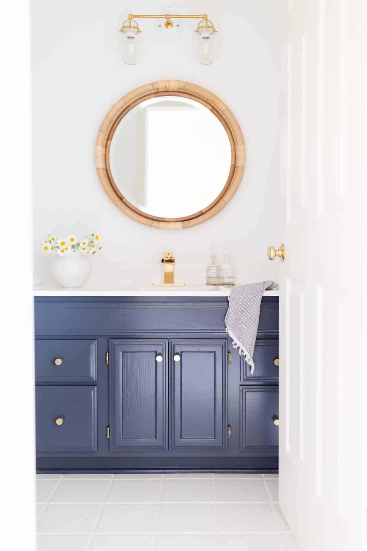 navy and white nautical bathroom with rattan mirror