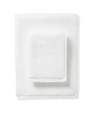 white bath towels stacked on top of one another