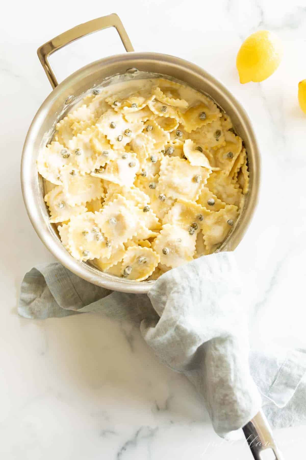 A pot full of ravioli in a lemon caper sauce