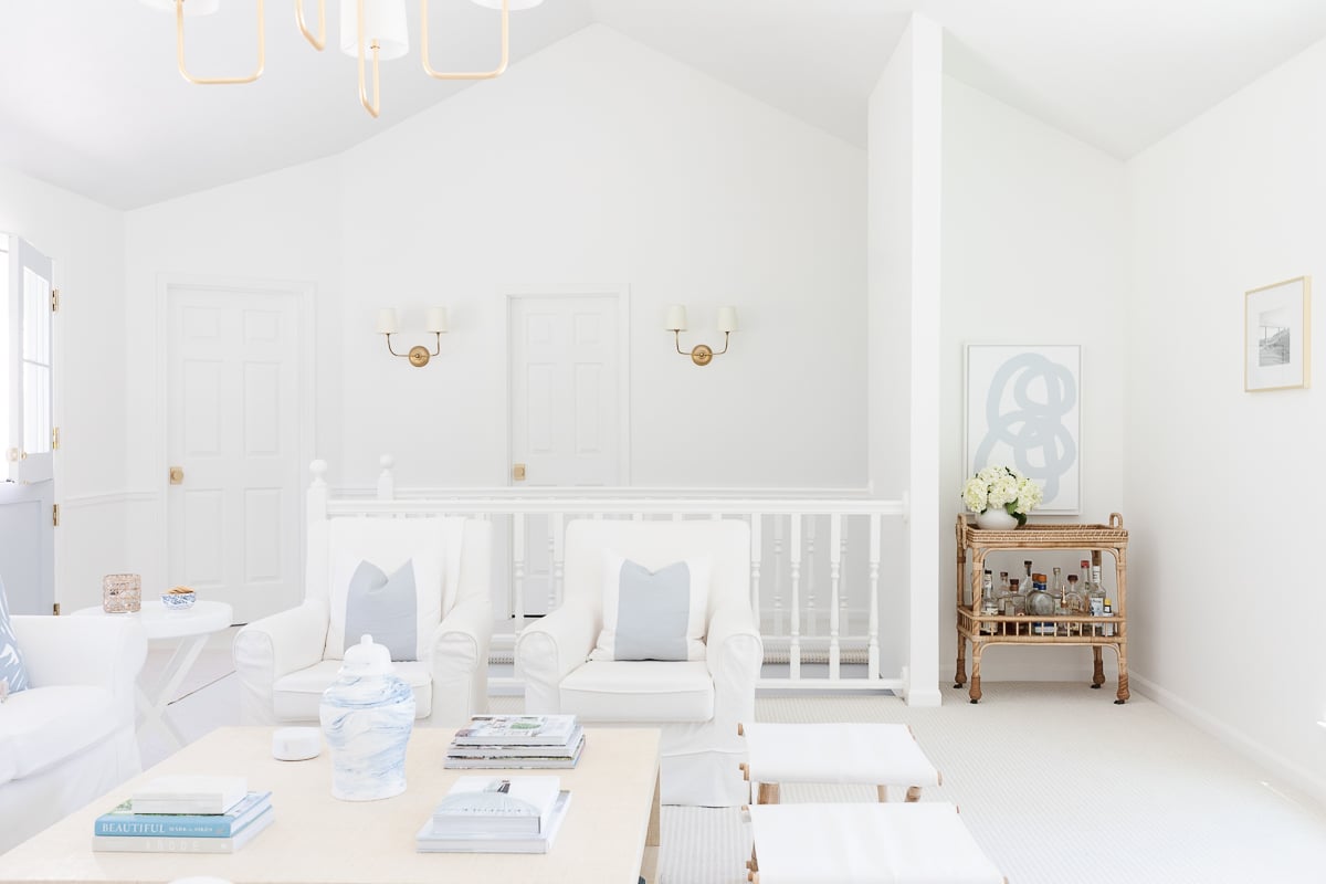 A white living room with blue accents, walls painted in Benjamin Moore Simply White.