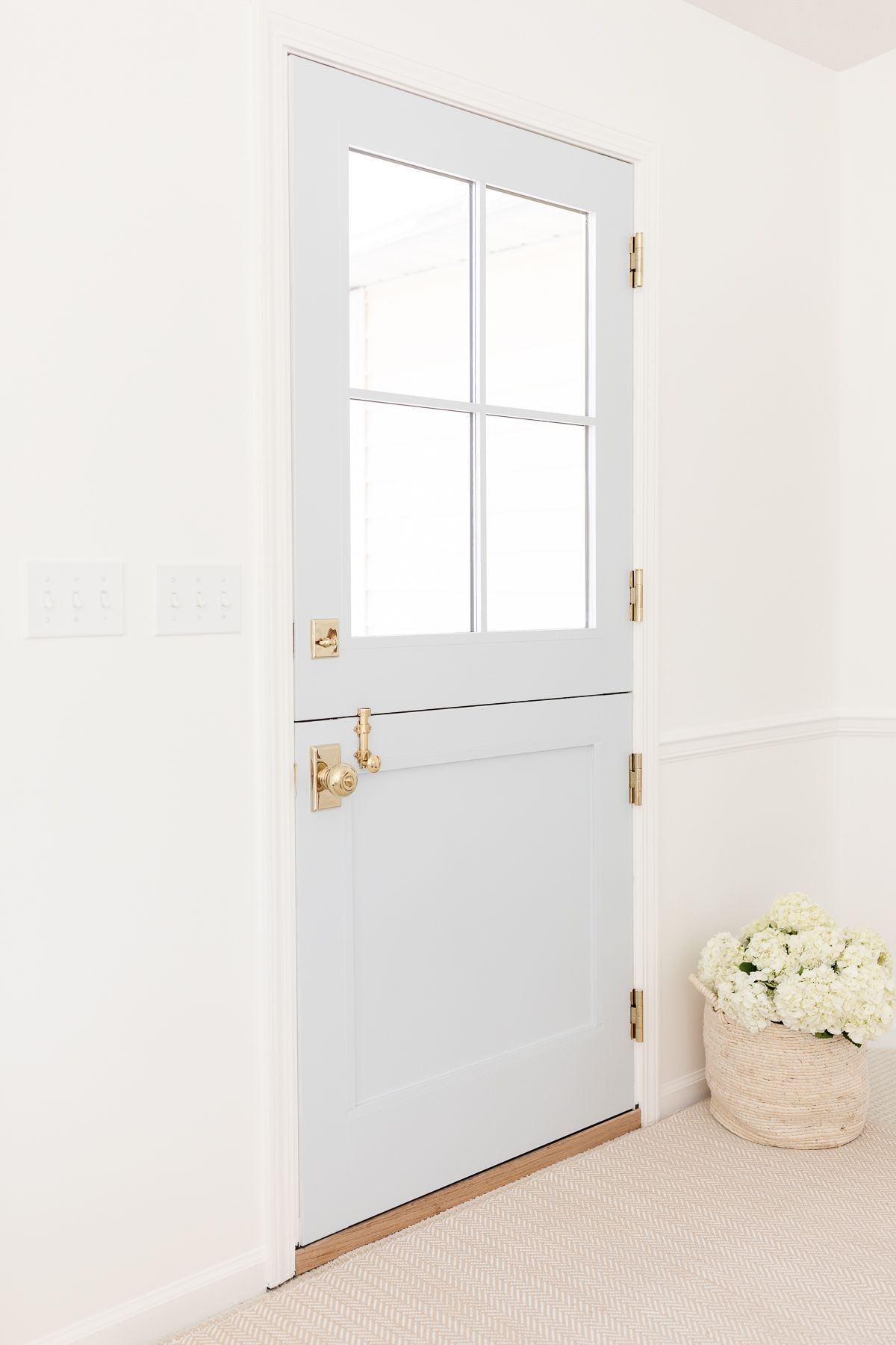 An entryway painted with Simply White walls and a blue Dutch door.