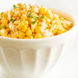 A white bowl of esquites (Mexican street corn salad).