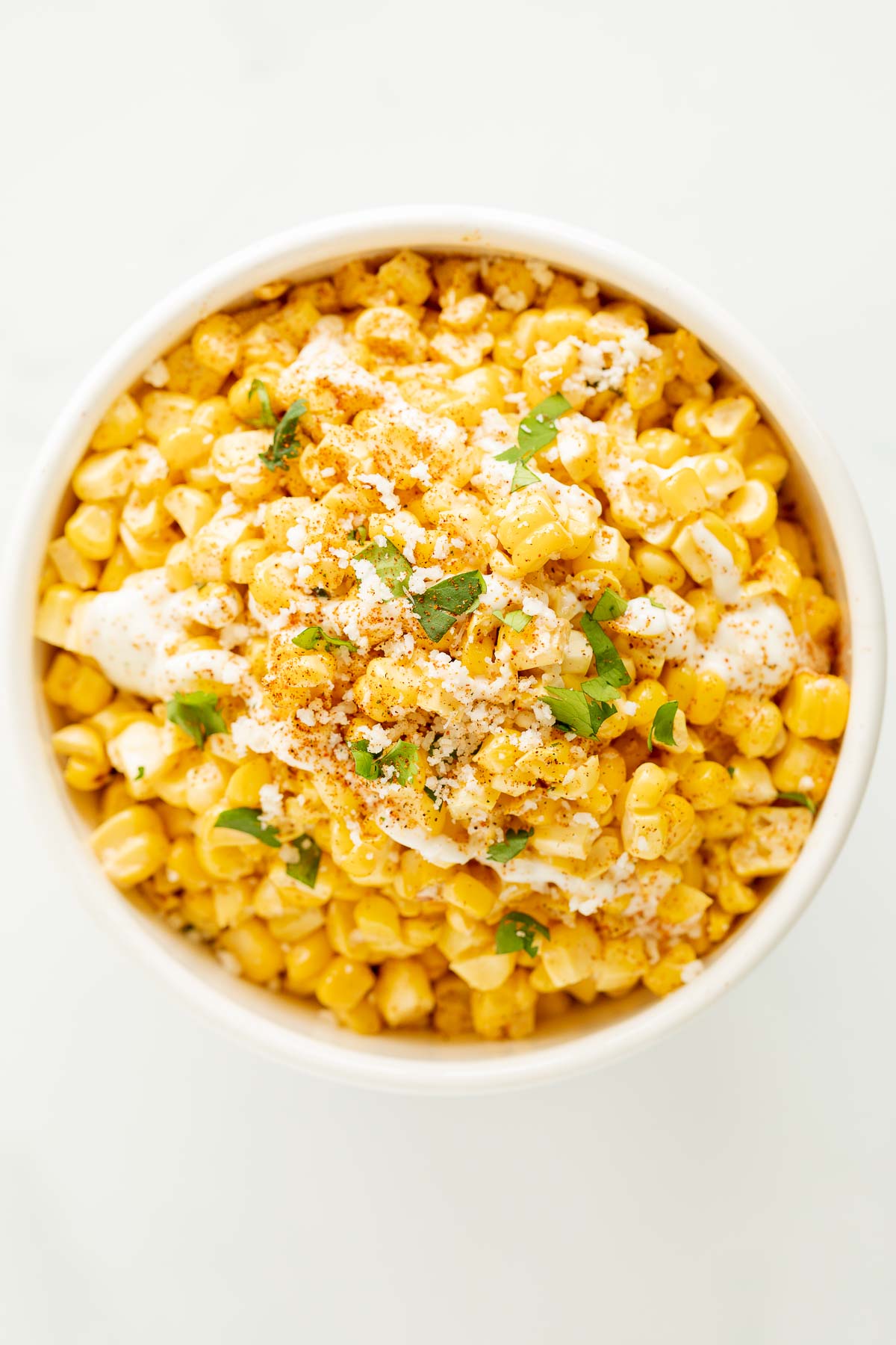 A white bowl of esquites (Mexican street corn salad).