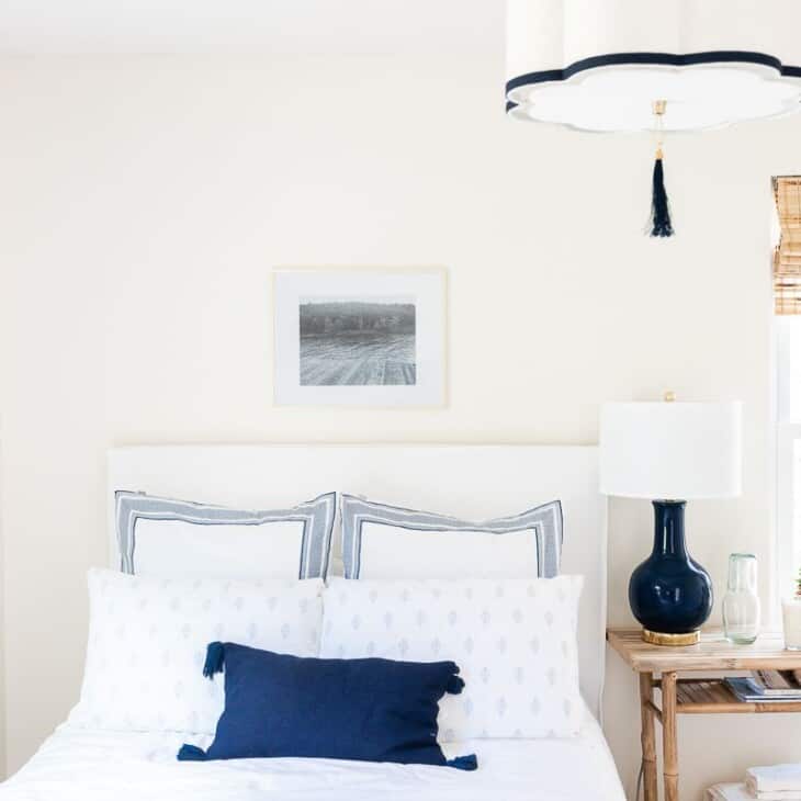 A navy and white guest bedroom with white guest bedding.