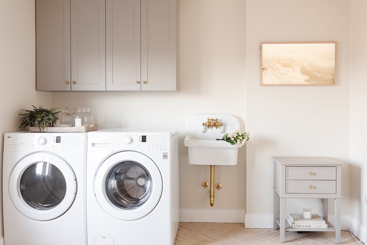 A laundry room with a wall sink and a Frame Tv
