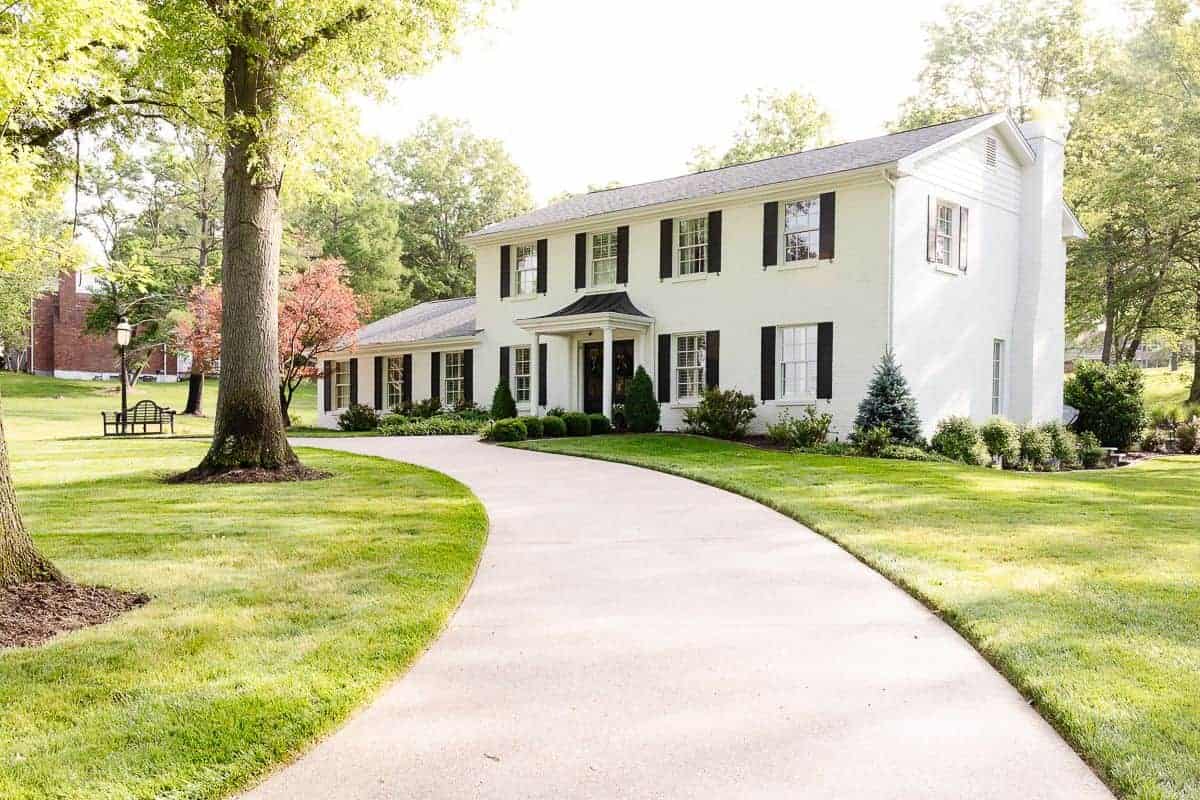 A colonial brick house painted in Benjamin Moore Simply White.