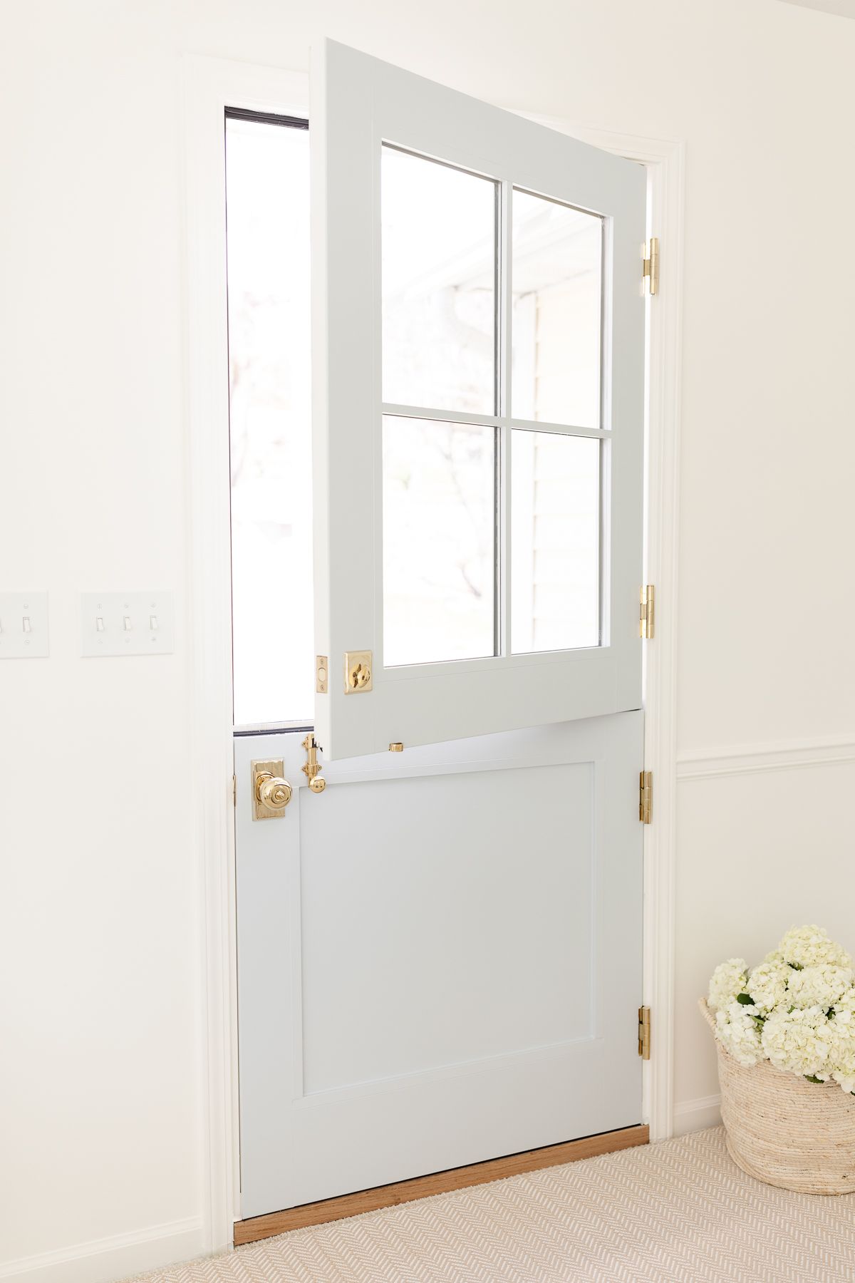 An entryway painted with Simply White walls and a blue Dutch door.