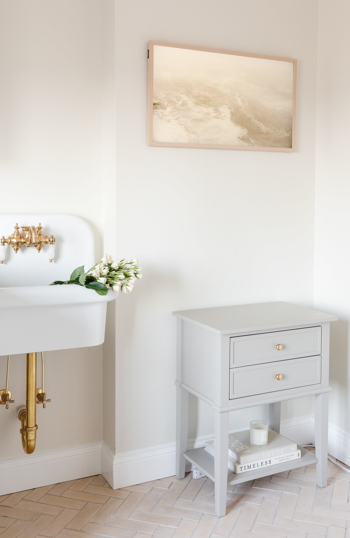 A laundry room with a white washer and dryer and a wall mount farmhouse sink.