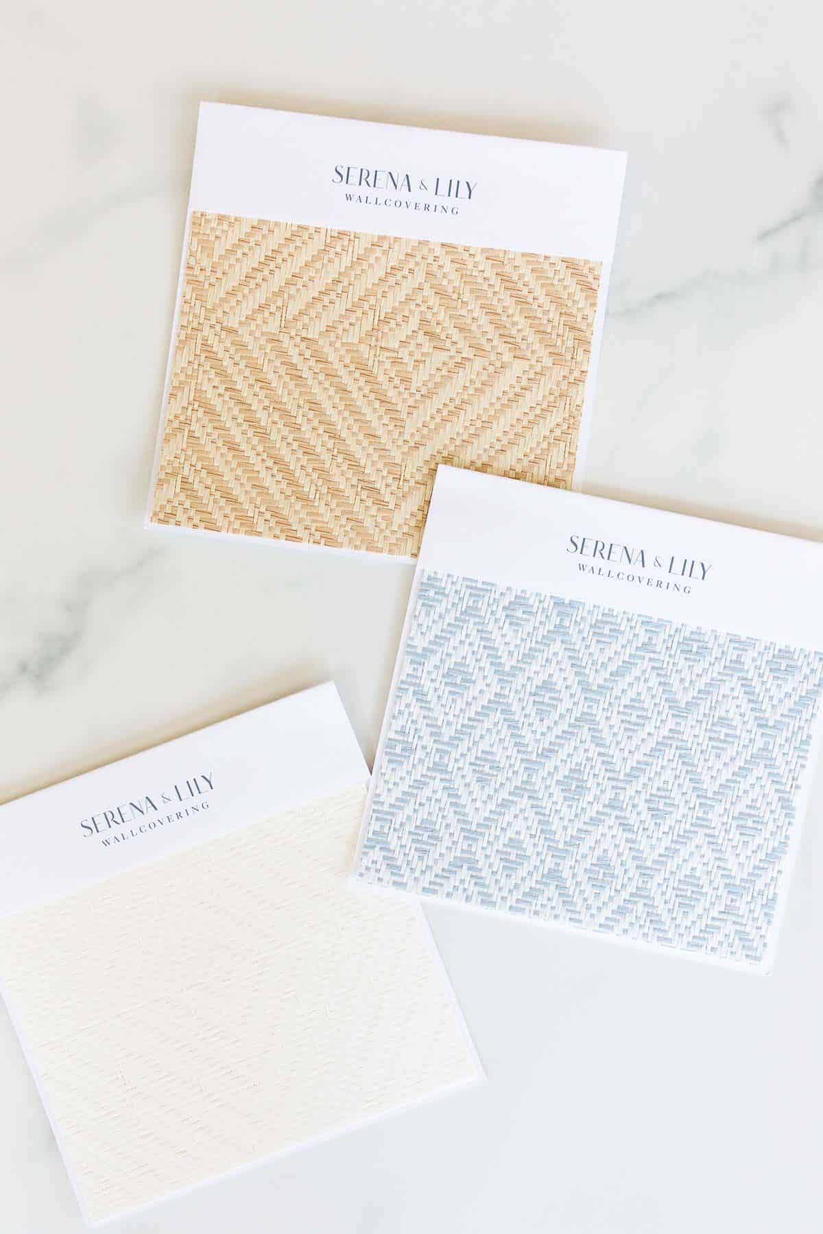 Wallpaper samples from Serena and Lily laid out on a marble surface.