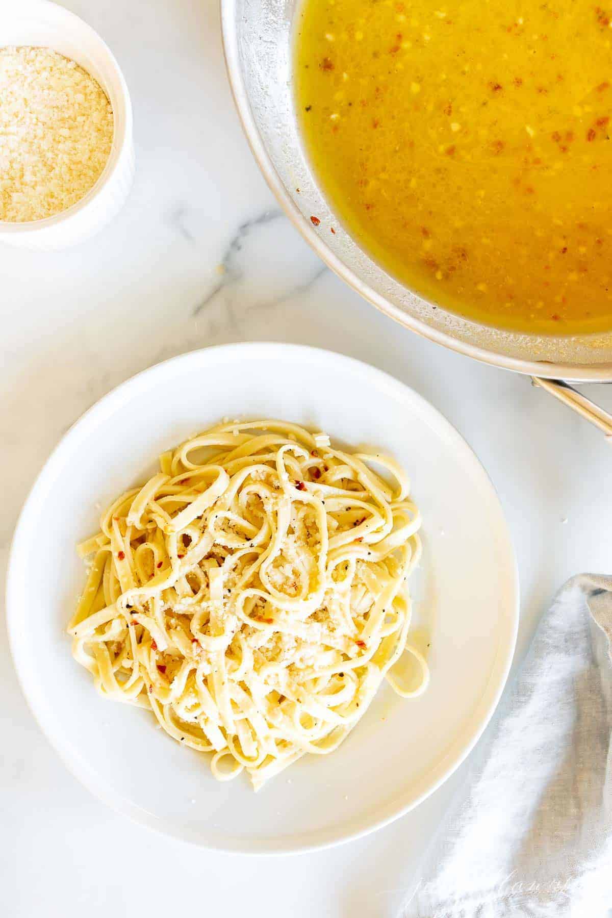 white wine sauce in a pan next to a plate of it