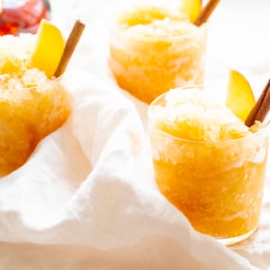 Apple cider slush with bourbon, garnished with a cinnamon stick