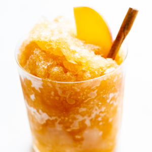 Apple cider slush with bourbon, garnished with a cinnamon stick