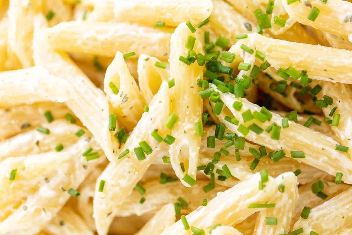 Close up of a boursin pasta recipe with penne, topped with chives.